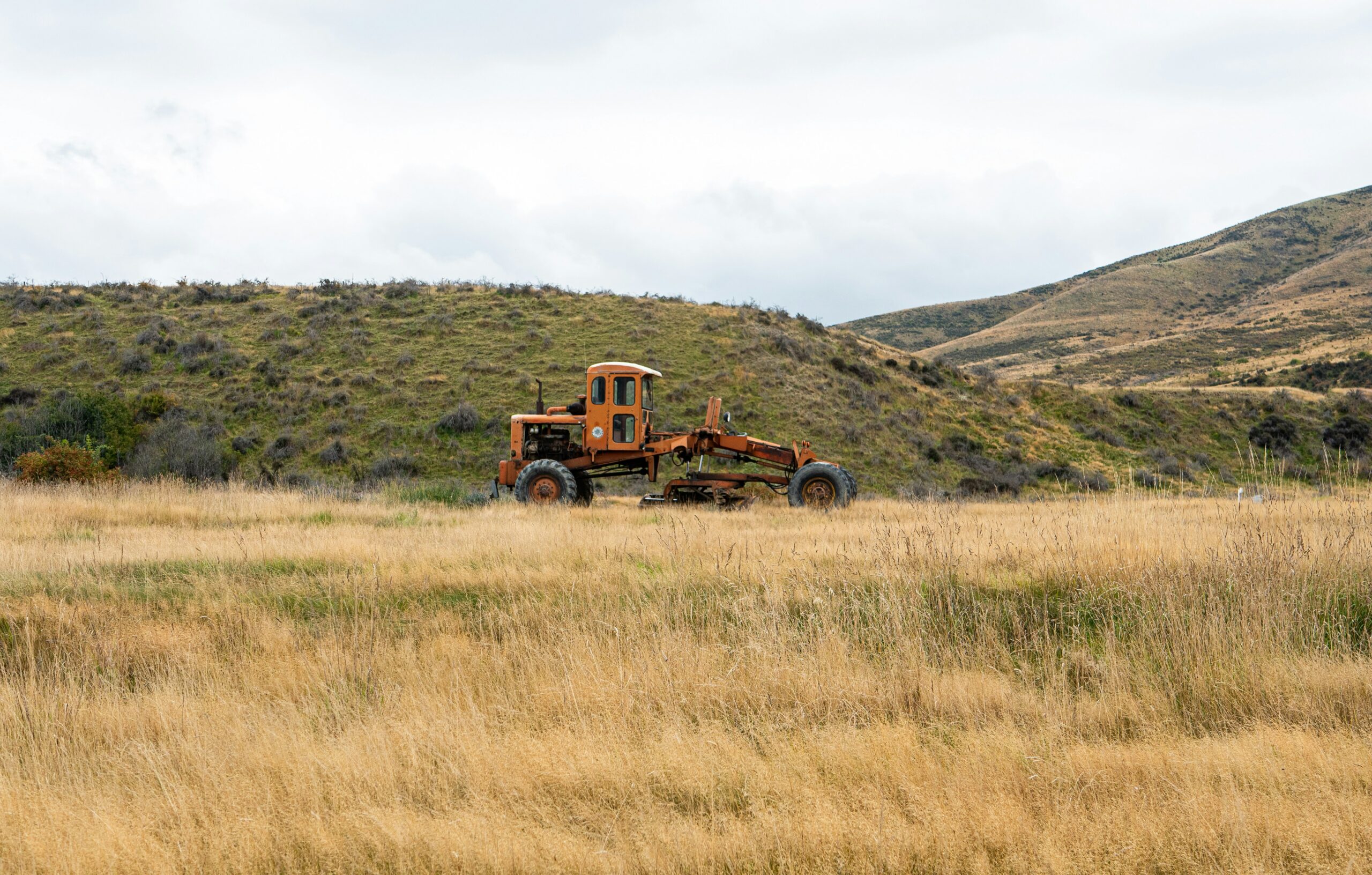 Omarama road grader in a rural landscape